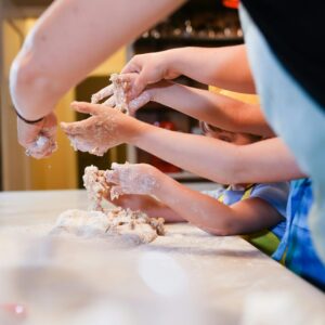 Engaging family cooking session with children making dough together.